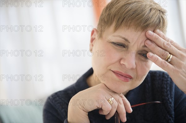 Anxious Caucasian woman rubbing forehead