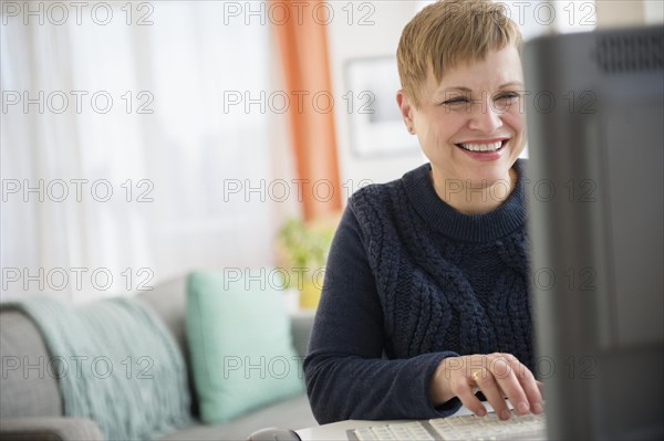 Laughing Caucasian woman using computer