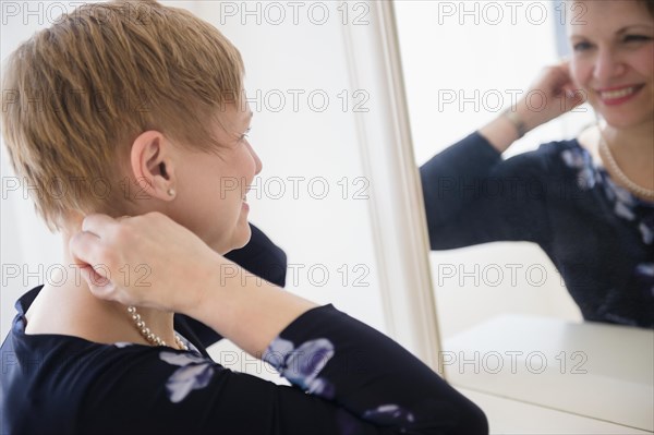 Caucasian woman admiring herself in mirror