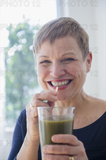 Caucasian woman drinking glass of healthy juice