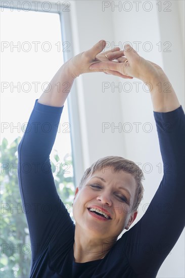 Caucasian woman stretching near window