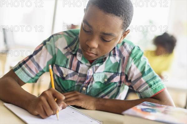 Black student writing in classroom