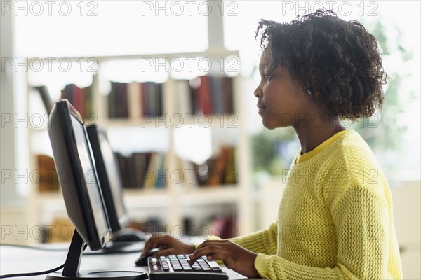 Black student using computer in classroom