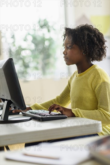 Black student using computer in classroom