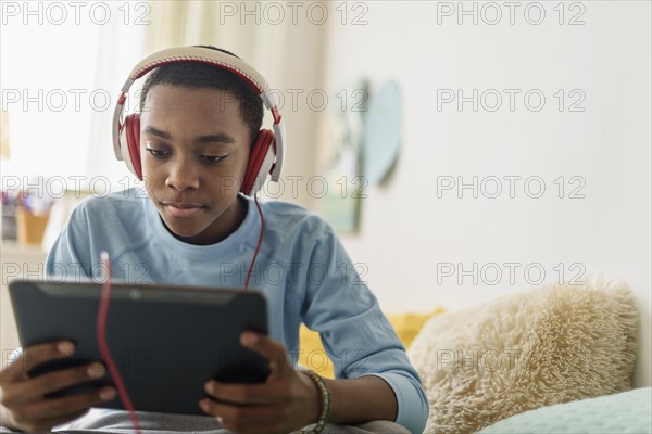 Black boy in headphones using digital tablet