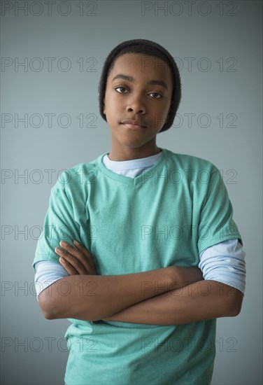 Stylish Black boy standing with arms crossed