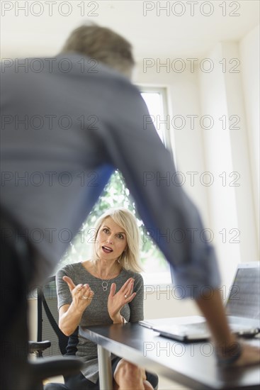 Older Caucasian business people arguing in office meeting