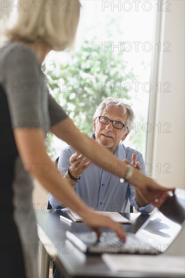 Older Caucasian business people arguing in office meeting