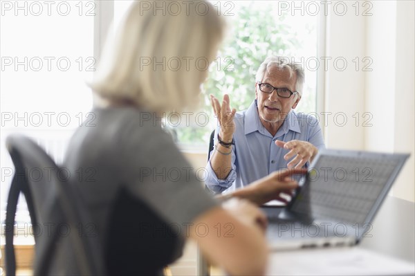 Older Caucasian business people arguing in office meeting
