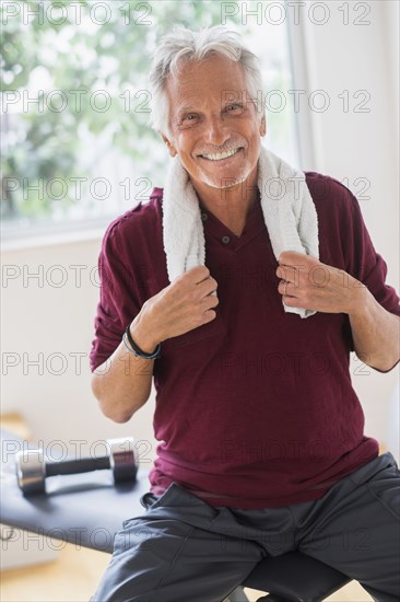 Smiling older Caucasian man resting in gym