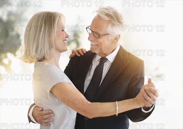 Smiling older Caucasian couple dancing