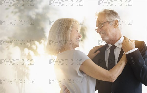 Smiling older Caucasian couple dancing