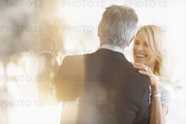 Smiling older Caucasian couple dancing