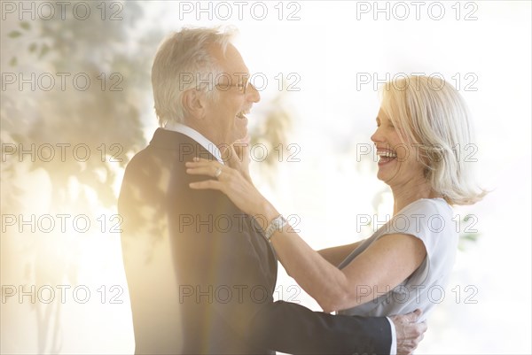 Smiling older Caucasian couple dancing