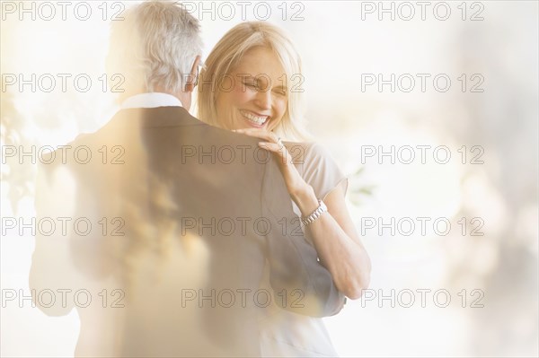 Smiling older Caucasian couple dancing