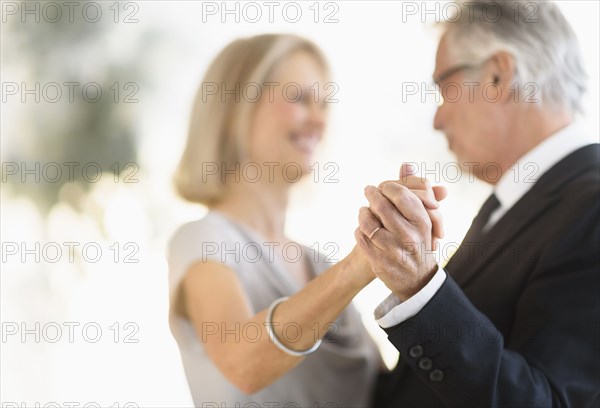 Smiling older Caucasian couple dancing