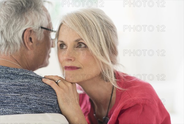 Close up of older Caucasian couple whispering