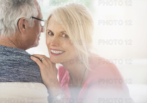 Close up of older Caucasian couple whispering