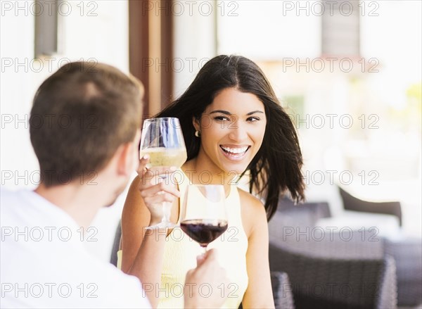 Hispanic couple toasting with wine