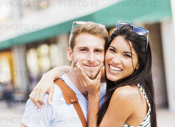 Hispanic couple hugging outdoors