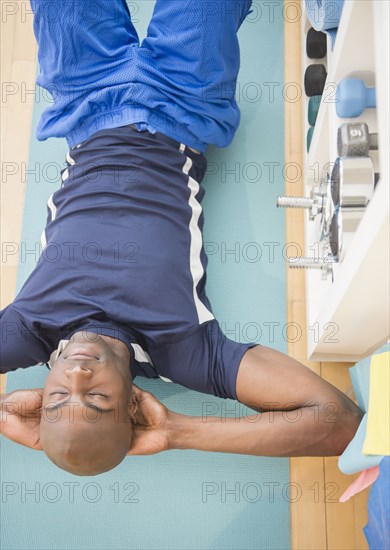 Black man doing sit-ups in gym