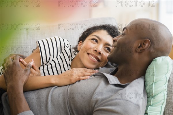 Smiling couple laying on sofa