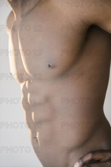 Black man flexing abdominal muscles