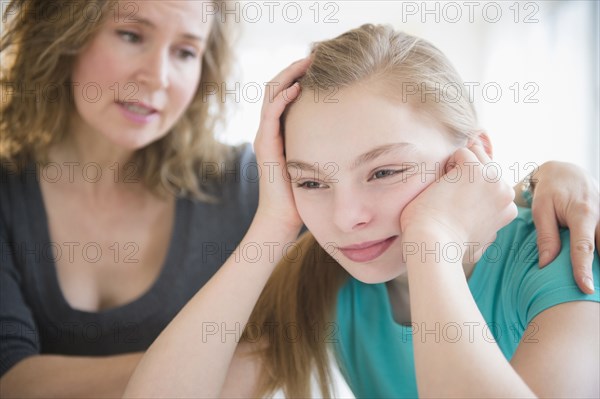 Caucasian mother comforting crying daughter