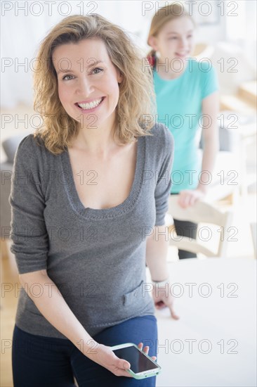 Caucasian woman holding cell phone in dining room