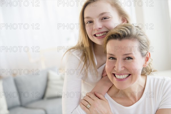 Caucasian mother and daughter smiling in living room