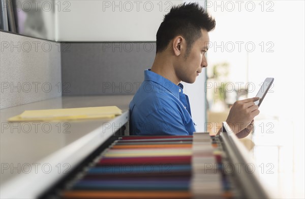 Chinese businessman using digital tablet in office