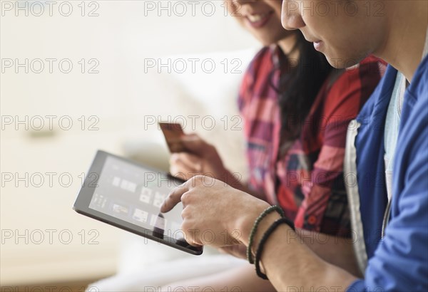 Close up of couple shopping online on digital tablet