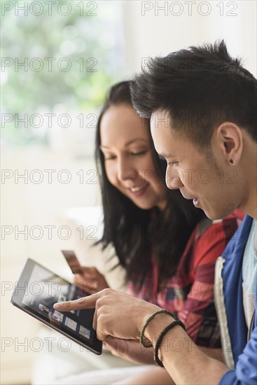 Close up of couple shopping online on digital tablet