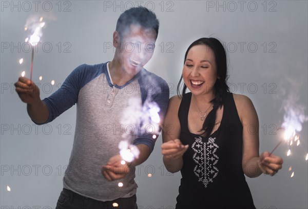 Smiling couple playing with sparklers