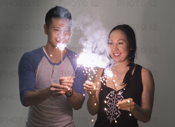 Smiling couple playing with sparklers