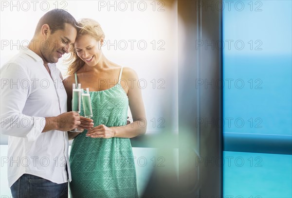 Couple drinking champagne at window