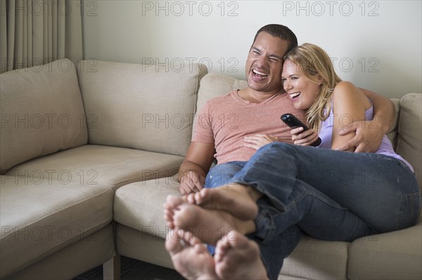 Couple watching television on sofa