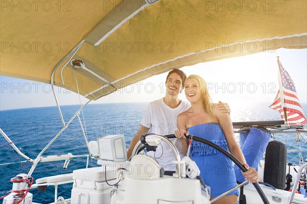 Couple steering boat on ocean