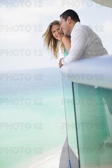 Couple hugging on balcony over ocean