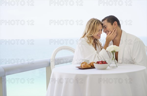 Couple eating breakfast on balcony