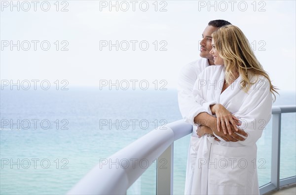 Couple hugging on balcony over ocean