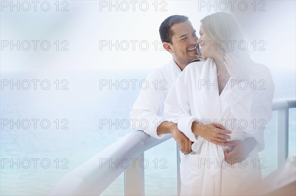 Couple hugging on balcony over ocean