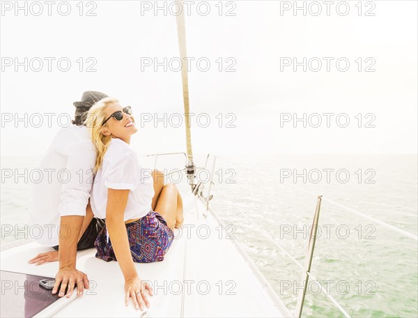 Couple cuddling on deck of sailboat