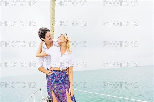 Couple hugging on deck of sailboat