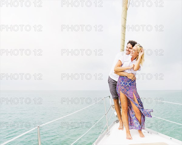 Couple hugging on deck of sailboat