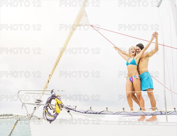 Couple standing on deck of sailboat