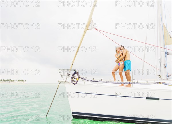 Couple hugging on deck of sailboat