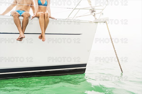 Couple sitting on deck of sailboat