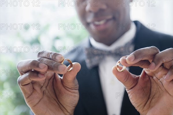 Close up of groom holding wedding rings