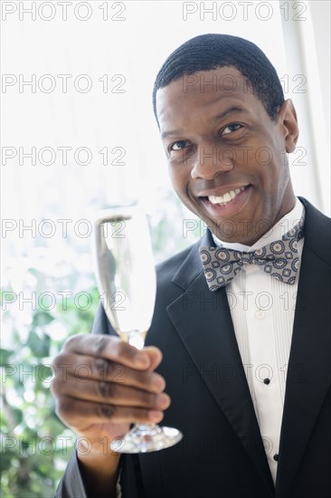 Smiling groom toasting with champagne